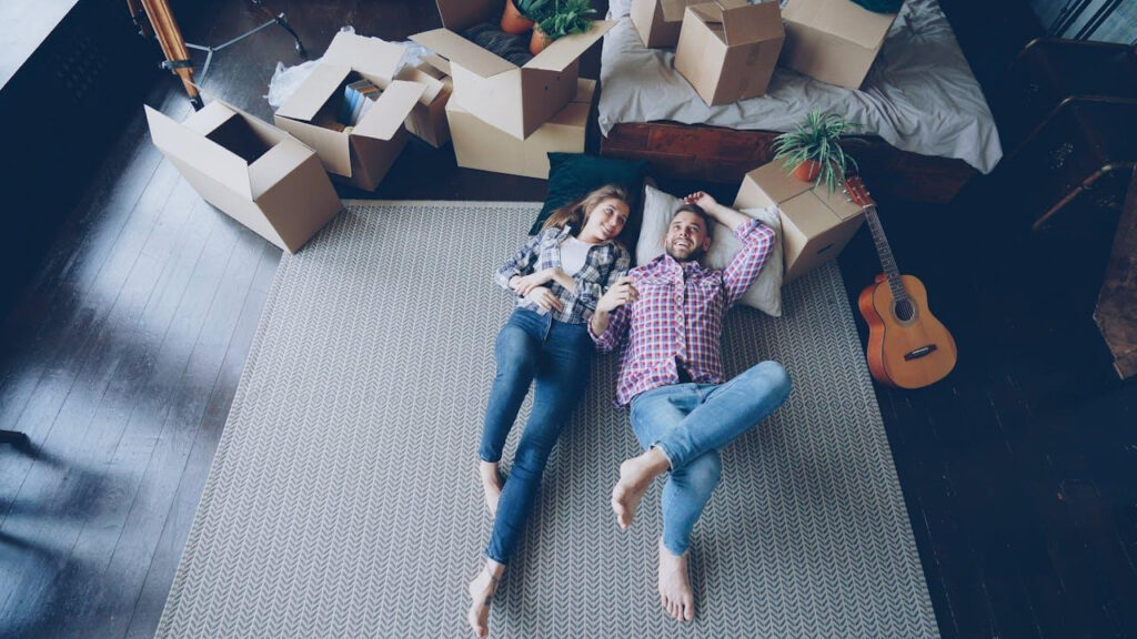 a happy couple resting after moving to a new place