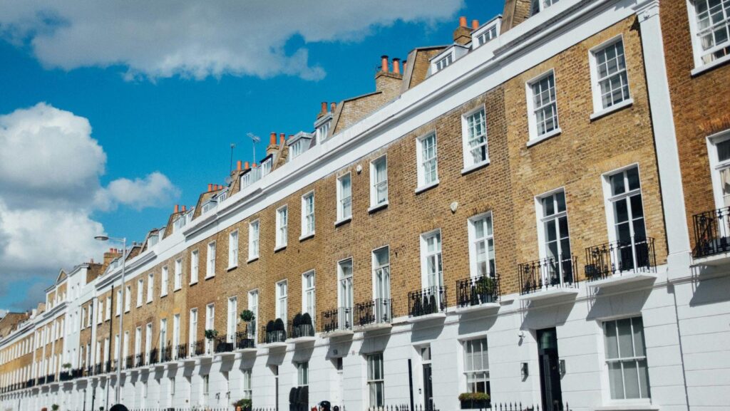 A row of traditional London terraced houses under a blue sky, the kind of period family home found across South East London.